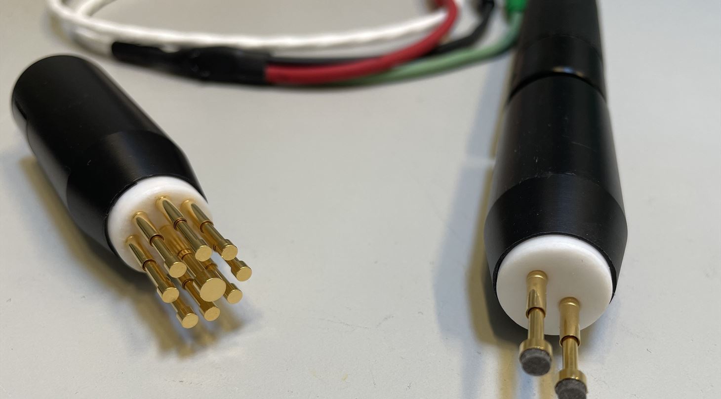 To prober til måling af elektriskledningsevne, specifikt overflademodstand. der ses to puder af elektriskledende gummi ved siden af hinanden på et håndtag som en tyk kuglepen. Den kan trykkes mod overfladen når ledningsevne skal måles